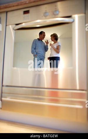 Couple drinking wine reflète dans une porte du four Banque D'Images