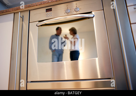 Couple drinking wine reflète dans une porte du four Banque D'Images