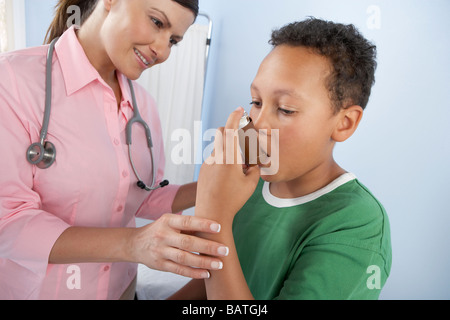 L'utilisation de l'inhalateur d'asthme.médecin demandant à un garçon sur la façon d'utiliser un inhalateur d'asthme. Banque D'Images