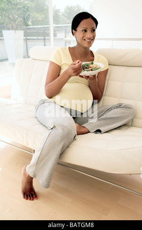 Pregnant woman eating a salad. Elle est à terme. Banque D'Images