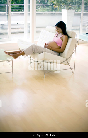 Femme enceinte avec ses pieds jusqu'au repos. Elle est à terme. Banque D'Images
