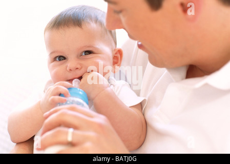 Nourrir bébé au biberon père.Père d'utilisation d'une bouteille de lait pour nourrir sa5-month-old baby girl. Banque D'Images