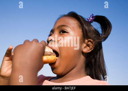 Girl eating a hamburger. C'est un burger de boeuf poêlé dans un sandwich. Banque D'Images