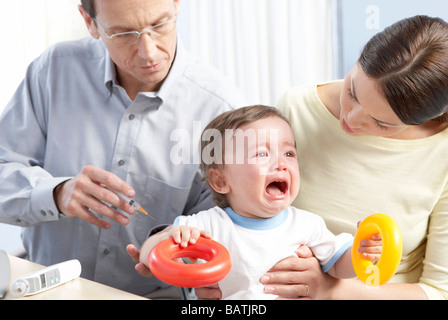 La vaccination des enfants. Un enfant de recevoir une injection d'un GP. Banque D'Images