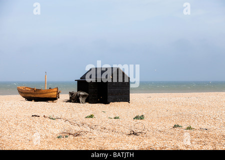 Construit à clins, traditionnel bateau de pêche et weatherboard cabane sur une plage de galets sur le Sud de l'Angleterre, côte de la Manche Banque D'Images