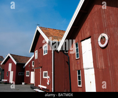 Bâtiments en bois rouge traditionnel à côté de port de Grundsund village sur la côte de la Suède sweden Banque D'Images