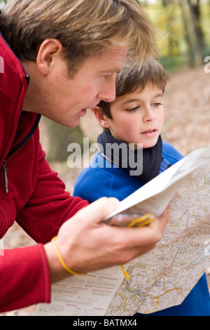 Père et fils la lecture d'un site.Le père tient un compas dans sa main droite. Une boussole peut être utilisé avec une carte. Banque D'Images