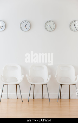 Rangée de chaises dans la salle d'attente en vertu de l'horloges affichage des fuseaux horaires Banque D'Images