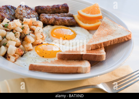 Sur la plaque des saucisses frites avec des œufs et des plaques en arrière-plan Banque D'Images