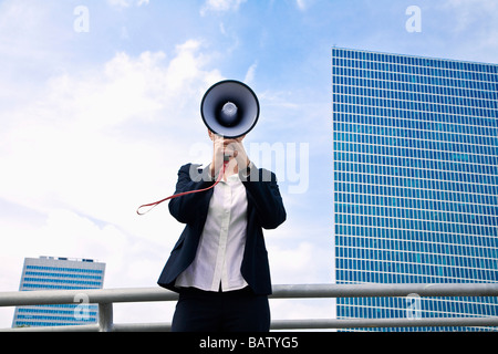 Portrait of young businesswoman caché derrière megaphone Banque D'Images