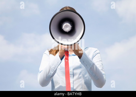 Portrait of young businesswoman caché derrière megaphone Banque D'Images