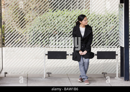 États-unis, Californie, San Francisco, jeune femme en attente à l'arrêt de bus Banque D'Images