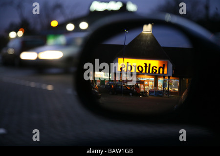 Un magasin Halfords reflétée dans un miroir de voiture Banque D'Images