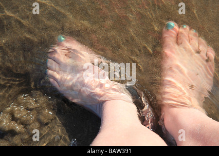 Pieds de la femme sur la plage avec l'eau de mer à ses ongles peints en vert Îles de Canaries Espagne Europe Banque D'Images