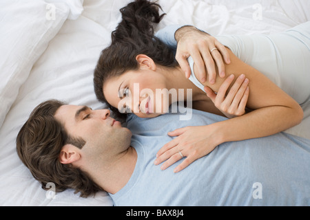 High angle view of Hispanic couple hugging in bed Banque D'Images