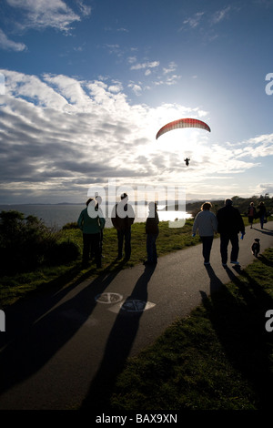 Un pilote parapente vole le long des falaises côtières Dallas Road à Victoria, BC, Canada. Banque D'Images