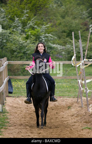 Une fille est en marche un cheval à l'maneage. Banque D'Images