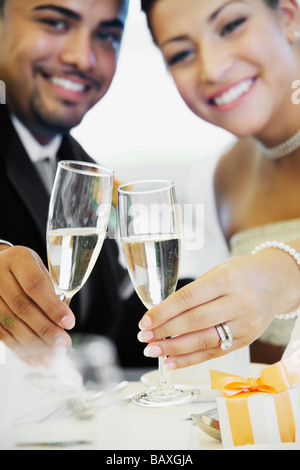 Multi-ethnic Bride and Groom toasting Banque D'Images