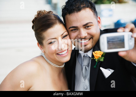 Multi-ethnic couple taking own photograph Banque D'Images