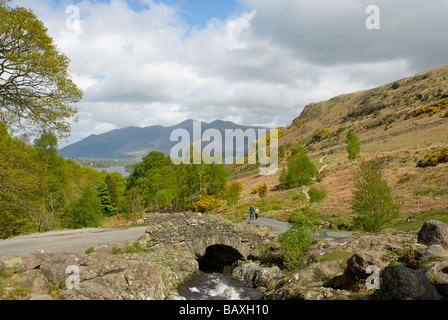 Deux marcheurs approcher Ashness Pont, donnant sur Skiddaw et Derwent Water, Parc National de Lake District, Cumbria, EnglandUK Banque D'Images