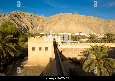 Forteresse et palmiers dans un paysage de montagnes, des monts Hajar, Kashab, Khasab, Oman, Musandam Banque D'Images