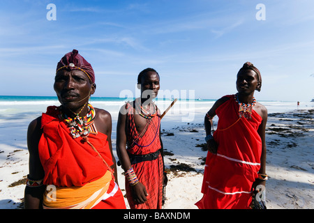 Trois Massai en plastique portant des vêtements traditionnels à la plage de Diani, Côte, Kenya Banque D'Images