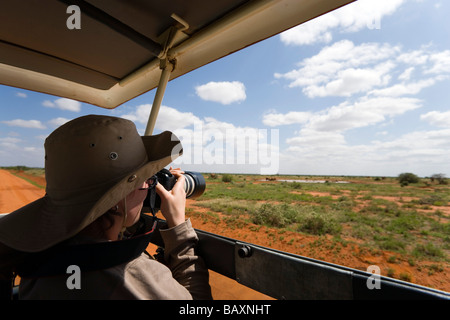 Femme photographying au cours de safari tour, le parc national de Tsavo Est, littoral, Kenya Banque D'Images