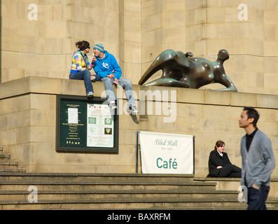 Les gens à l'extérieur de détente Leeds Art Gallery, à côté de la sculpture de Henry Moore, femme allongée, West Yorkshire, England UK Banque D'Images