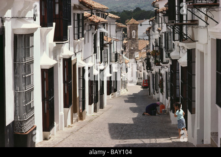 Jeune fille qui marche sur l'allée pavée dans le village blanc Grazalema, Cadiz Province, Andalusia, Spain Banque D'Images