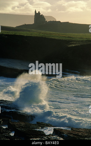 Paysage côtier avec des vagues se briser sur la plage, silhouette du château de Mullaghmore dans l'arrière-plan, dans le Comté de Leitrim, Ireland Banque D'Images