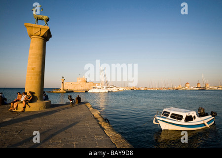 Les gens se reposer sur la base de la colonne avec le cerf Elafos à port entrée du port de Mandraki (traduit littéralement : pli), colonne avec Banque D'Images