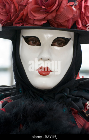 Seule fille dans un déguisement carnaval vénitien noir avec roses rouges Banque D'Images