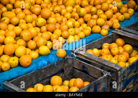 Des piles d'oranges sur cale et dans des caisses, à vendre dans le marché aux fruits à l'intérieur de la médina de Fès, Maroc. Banque D'Images