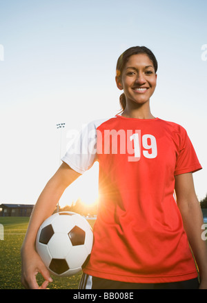 Mixed Race woman posing with soccer ball Banque D'Images