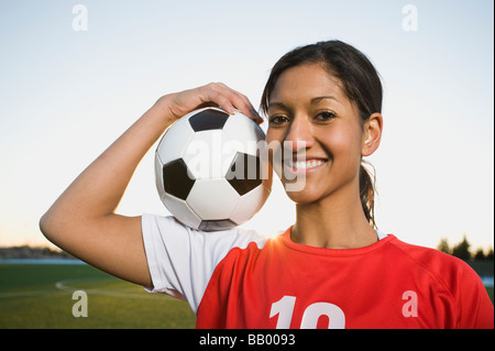 Mixed Race woman posing with soccer ball Banque D'Images