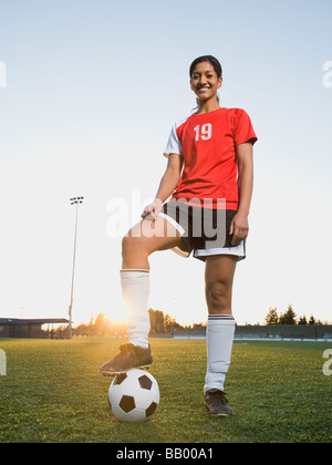 Mixed Race woman posing with soccer ball Banque D'Images