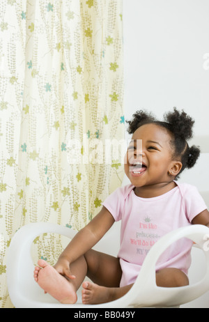 African American girl laughing in chair Banque D'Images
