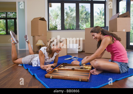 Hispanic teenage girls playing backgammon Banque D'Images