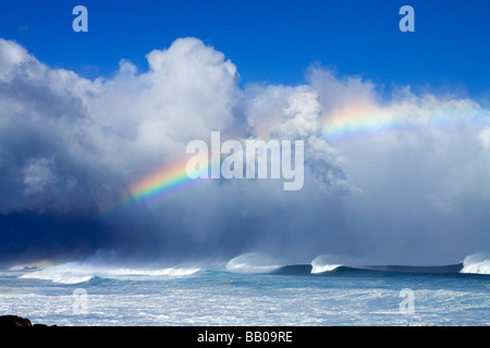 De grosses vagues et un arc-en-ciel à Ho'okipa Beach, Maui, Hawaii. Banque D'Images