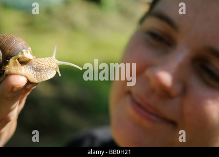 Femme tenant la main d'escargots Helix pomatia Europe garden Banque D'Images