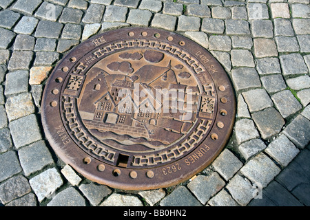 Grille de Drainage décorées dans le contraindre chaussée de pierre du Bryggen à Bergen, Norvège Banque D'Images