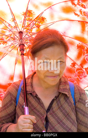 Jolie femme asiatique Hmong âgées sous un parasol. Sports Festival Hmong McMurray Domaine St Paul Minnesota USA Banque D'Images