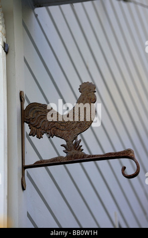 Metal sculpture de coq silhouetté contre mur intéressant Banque D'Images