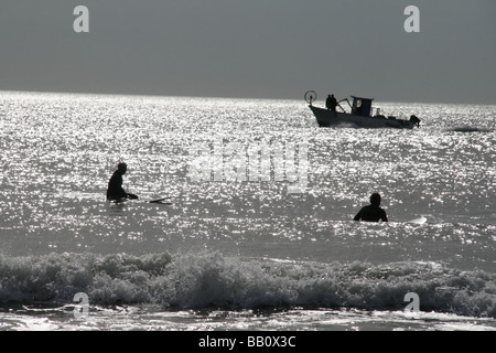 Les surfeurs et bateau de pêche en mer à Ostia Italie Banque D'Images