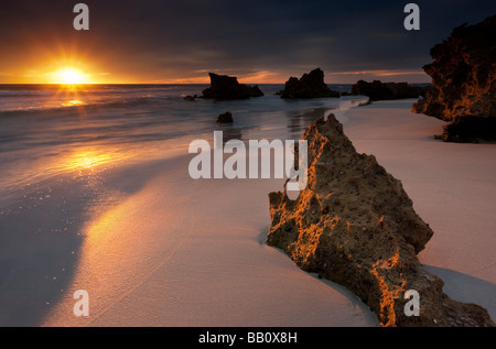 Le soleil tombant dans l'Océan Indien à Trigg Beach à Perth, Australie occidentale Banque D'Images