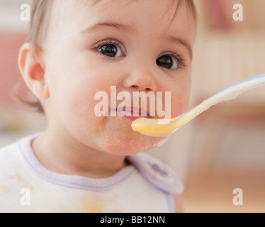 Mixed Race baby girl eating Banque D'Images