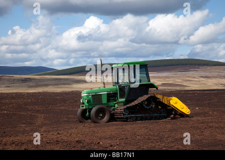 Extraction de l'abatteuse John Deere Tractor Peat Harvester: Récolte de la tourbe de sphagnum écossaise, tourbière de la moorland de Tomintoul, parc national de Cairngorms, Écosse, Royaume-Uni Banque D'Images