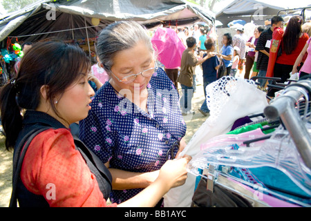 Femme de l'adolescence et la grand-mère shop pour les vêtements dans les Hmong du marché asiatique. Sports Festival Hmong McMurray Domaine St Paul Minnesota USA Banque D'Images