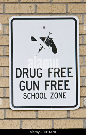 Gun free drug free zone scolaire sign posted on wall Banque D'Images