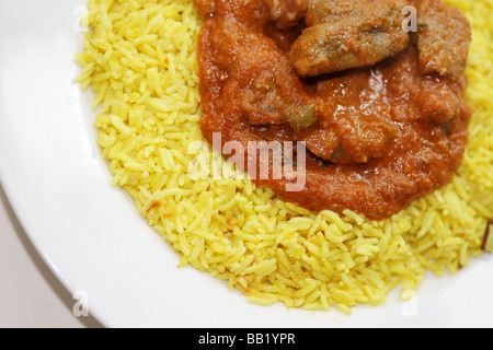 Le style indien authentique Curry Rogan Josh d'agneau avec riz Pilau aromatique jaune et pas de personnes Banque D'Images